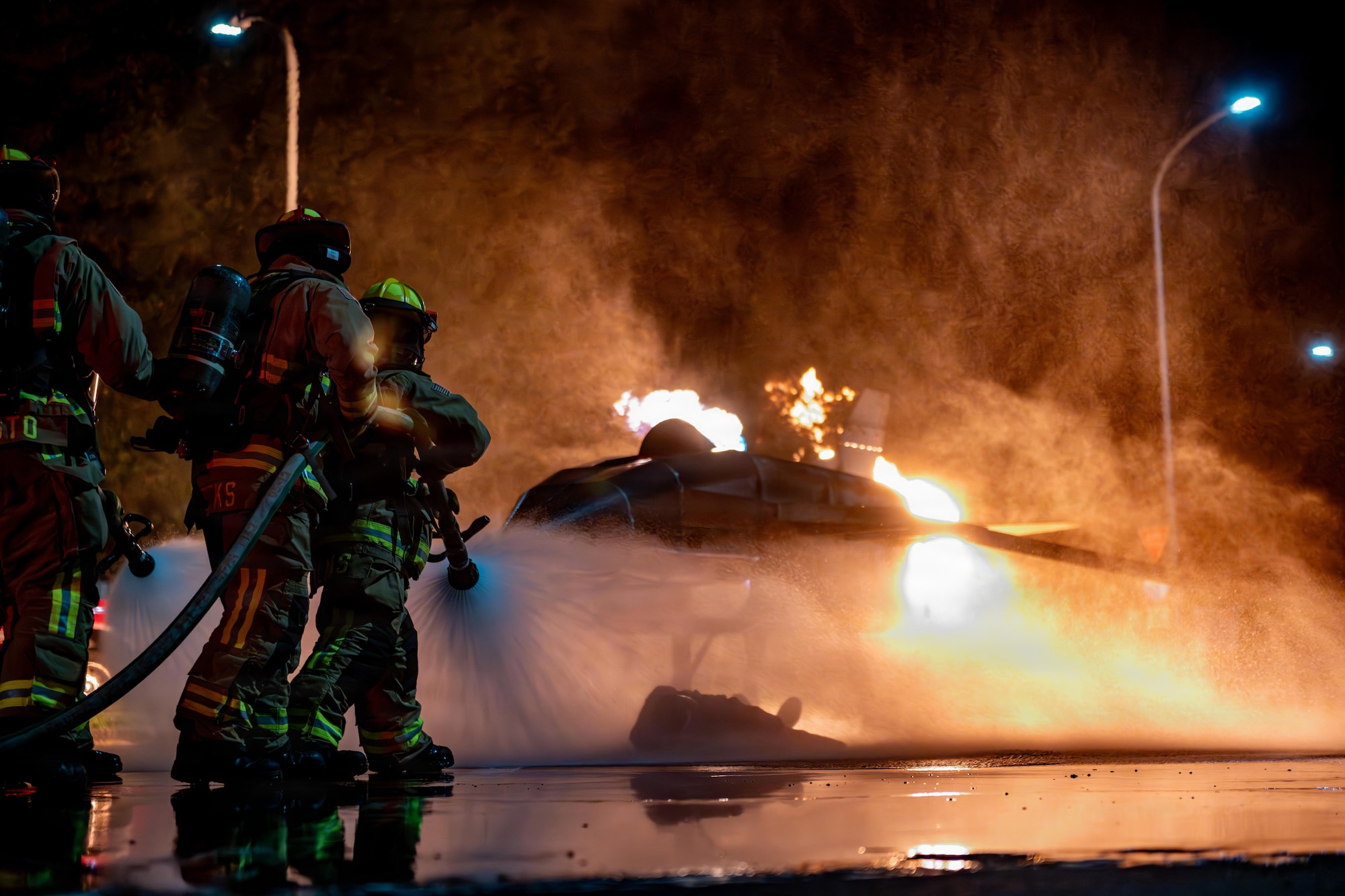 U.S. Air Force Airmen assigned to the 35th Civil Engineer Squadron spray a simulated burning aircraft during Fire Prevention Week 2025.