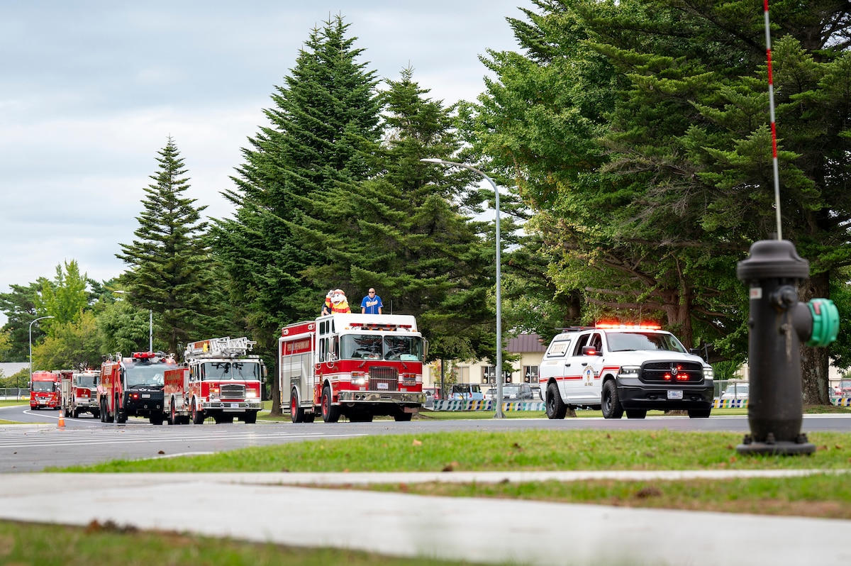 35th Civil Engineer Squadron Fire & Emergency Service vehicles drive around base during a Fire Prevention Week parade at Misawa Air Base, Japan, Oct. 5, 2025. This year’s observance focuses on lithium battery safety, emphasizing how everyday precautions strengthen base-wide protection and resilience. (U.S. Air Force photo by Senior Airman Brittany Russell)