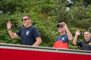 U.S. Air Force members assigned to the 35th Fighter Wing wave and pass out candy from the top of a fire truck during a Fire Prevention Week parade at Misawa Air Base, Japan, Oct. 5, 2025. Fire Prevention Week is observed annually and reinforces the importance of proactive safety measures, keeping the 35th Fighter Wing secure and mission-ready. (U.S. Air Force photo by Senior Airman Brittany Russell)