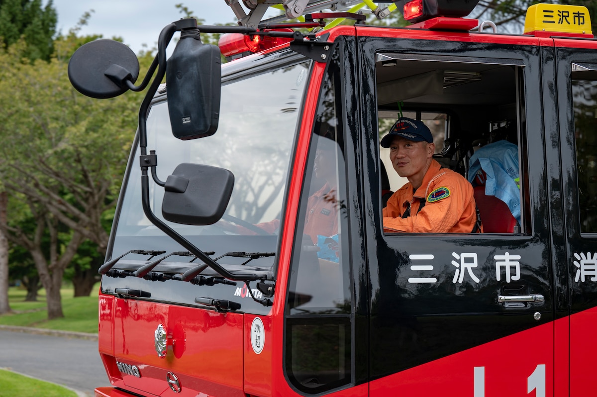 A Misawa City Fire Department member drives a fire truck around base during a Fire Prevention Week parade at Misawa Air Base, Japan, Oct. 5, 2025. These efforts enhance awareness and preparedness, helping protect Airmen, families and critical resources while sustaining the 35th Fighter Wing’s mission. (U.S. Air Force photo by Senior Airman Brittany Russell)
