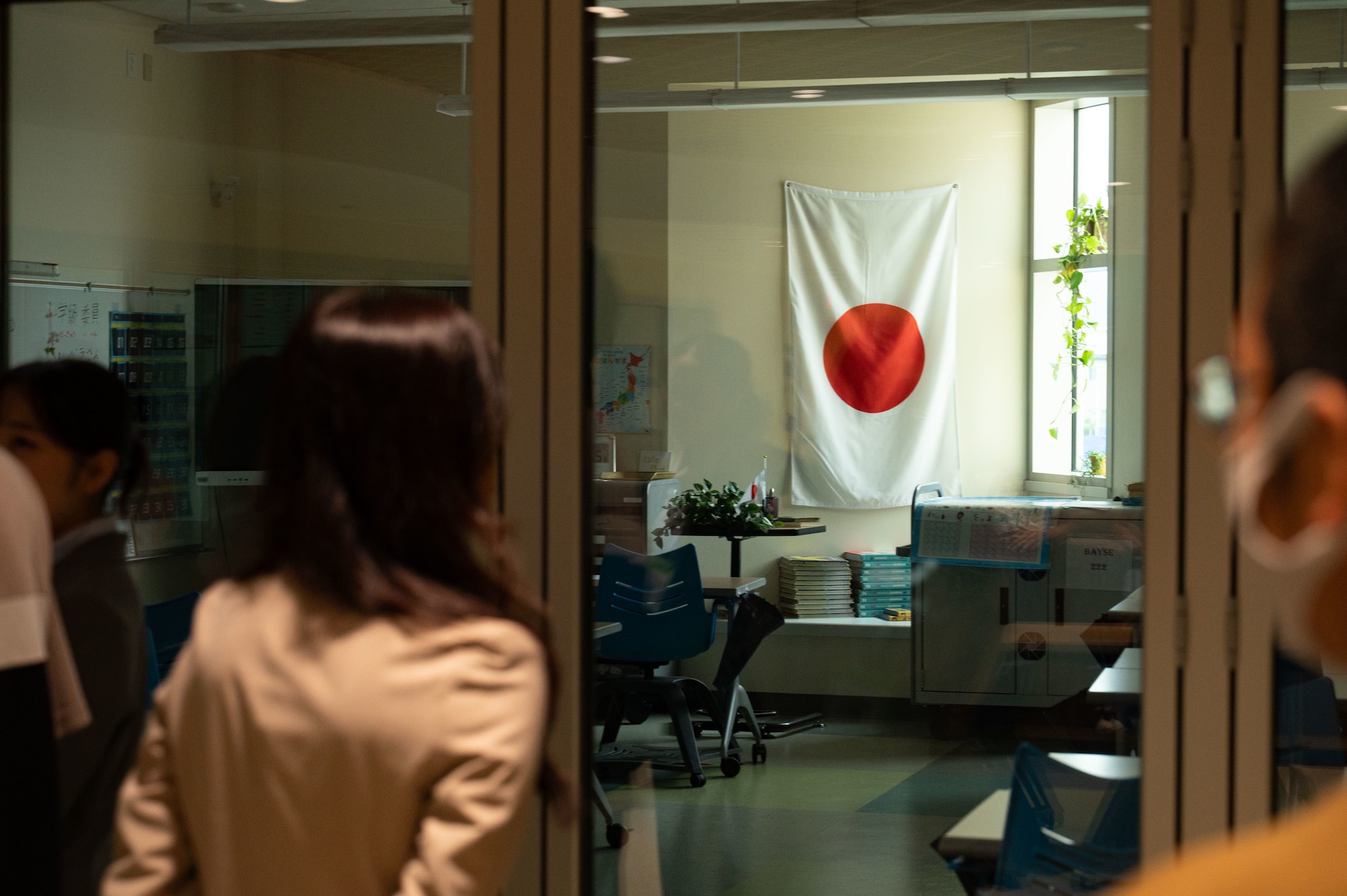 Students gaze at a Japanese flag displayed in a classroom.