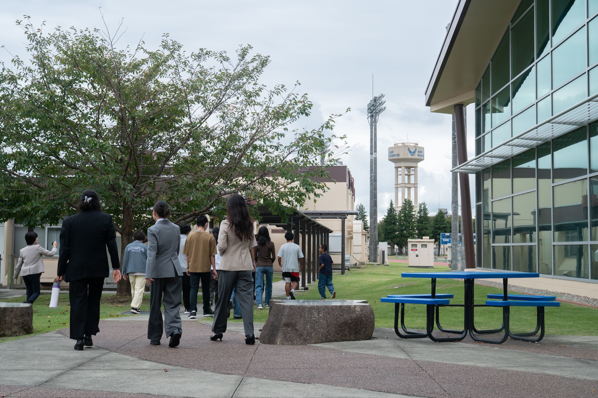 A group of people walk outside of a building.