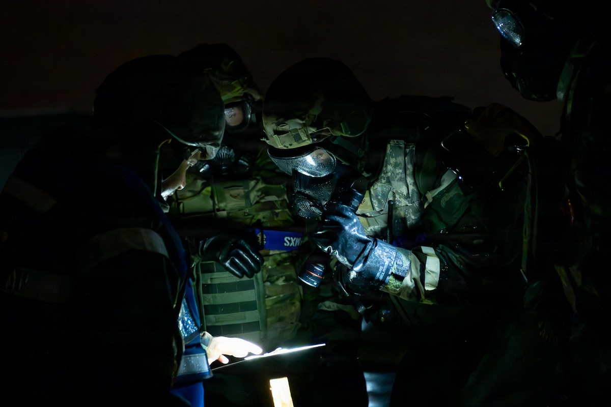 U.S. Air Force Airmen assigned to the 35th Maintenance Group inspect a simulated M8 chemical agent detection tape for contamination during exercise Beverly Sunrise (BS) 26-01.