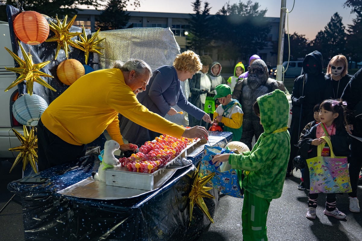A participant passes out candy during Trunk or Treat at Misawa Air Base, Japan, Oct. 24, 2025. Through events like this, the 35th Fighter Wing continues to prioritize quality experiences that promote unity, connection and community spirit. (U.S. Air Force photo by Senior Airman Brittany Russell)