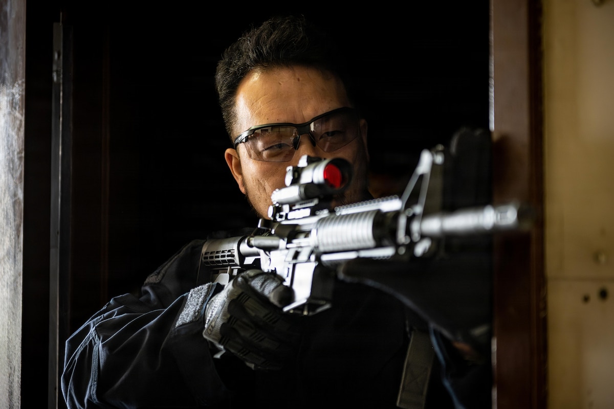 A Japanese National Police Special Investigation Team member guards the hallway in a breaching exercise during a joint special weapons and tactics training event.
