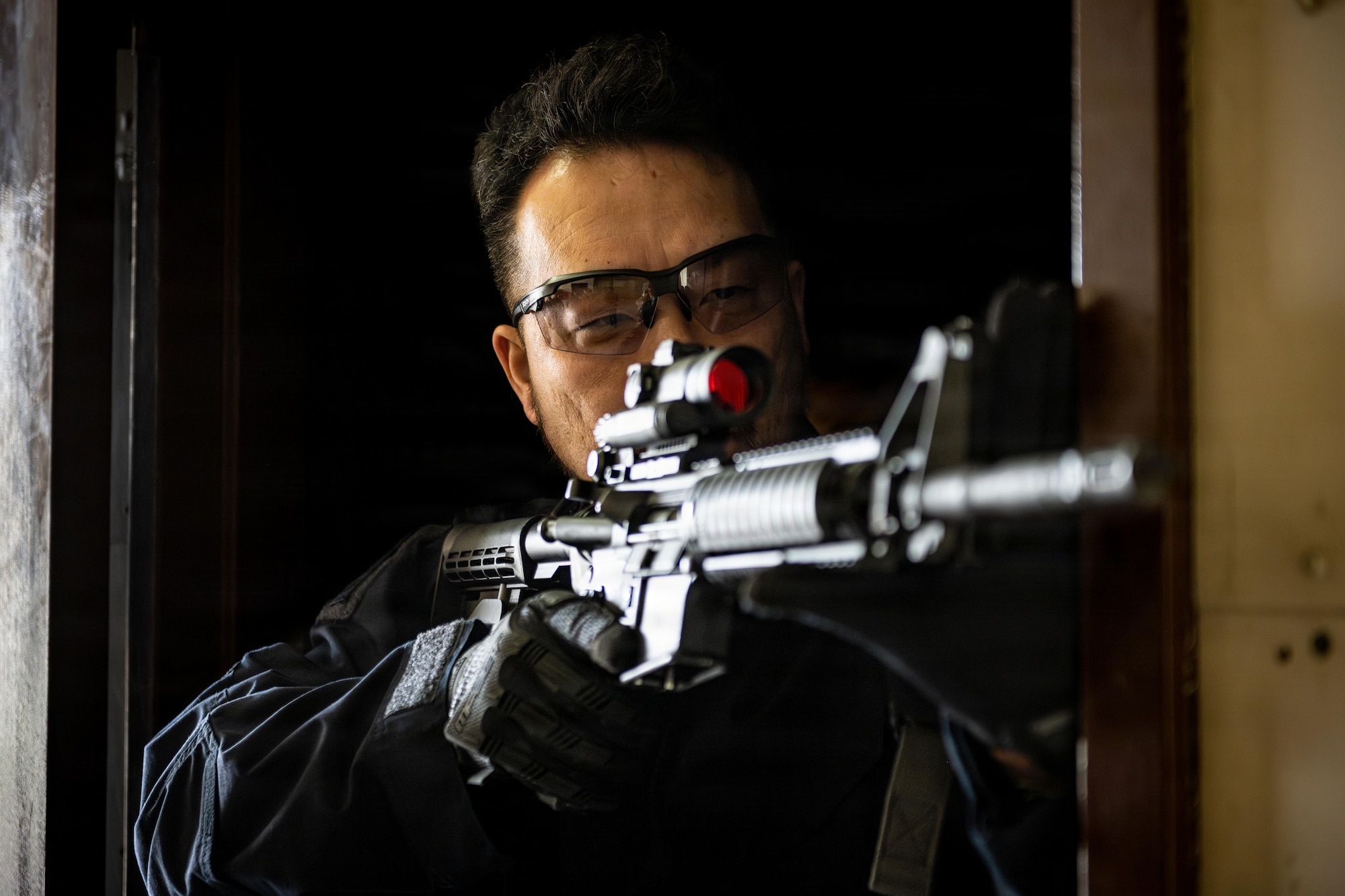 A Japanese National Police Special Investigation Team member guards the hallway in a breaching exercise during a joint special weapons and tactics training event.