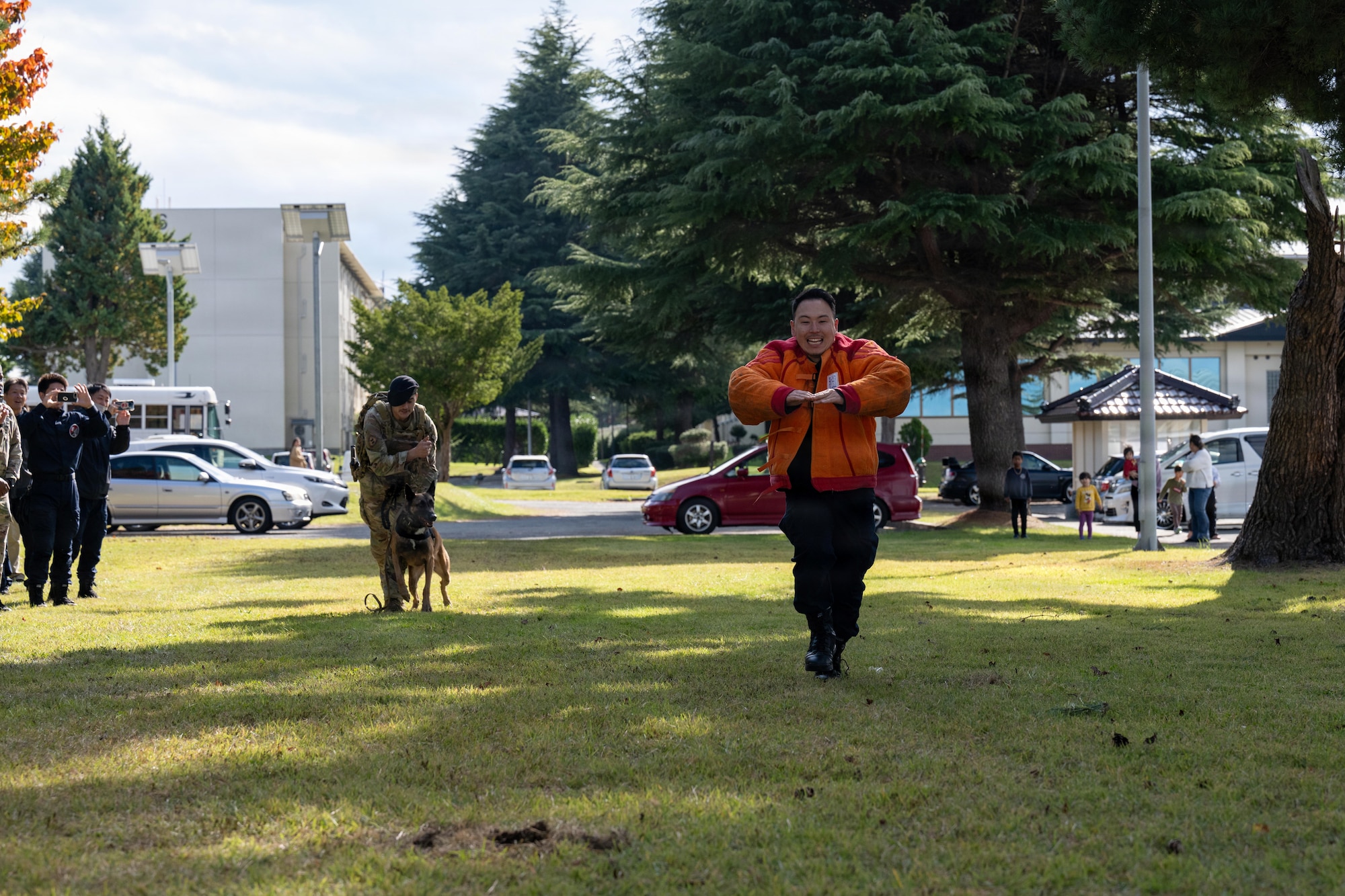 A Japanese National Police Special Investigation Team member runs away from Clinton, 35th Security Forces Squadron military working dog, as part of a demonstration during a joint special weapons and tactics training event.
