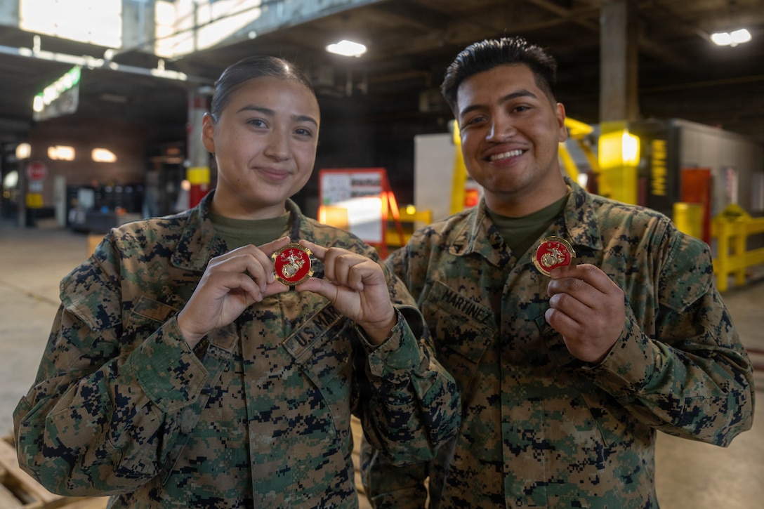 U.S. Marine Corps Lance Cpl. Cina Reyes, left, an inventory management specialist, and Lance Cpl. Jorge Martinez, a supply chain specialist, both with 2nd Combat Readiness Regiment, 2nd Marine Logistics Group, pose for a photo after receiving challenge coins from U.S. Marine Corps Brig. Gen. Joel Schmidt, assistant division commander, 2d Marine Division, at Marine Corps Base Camp Lejeune, North Carolina, Nov. 4, 2025. The assistant division commander visited 2nd CRR Marines to learn how they provide higher levels of supply management and maintenance to II Marine Expeditionary Force in garrison and while forward deployed. (U.S. Marine Corps photo by Lance Cpl. Javier Santillan)