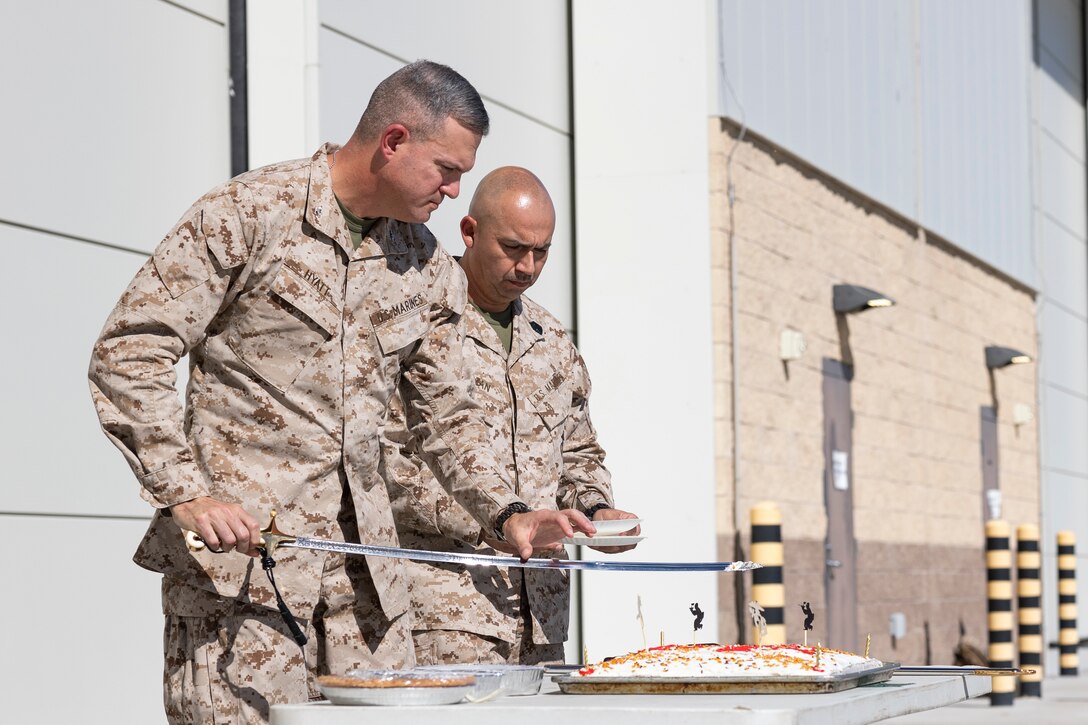 U.S. Marine Corps Col. Caleb Hyatt, left, the commanding officer of the 11th Marine Expeditionary Unit, I Marine Expeditionary Force, and Sgt. Maj. Geronimo Guzman, the sergeant major of the 11th MEU, cut a slice of cake to celebrate the 250th birthday of the Marine Corps during Realistic Urban Training at Marine Corps Air Station Yuma, Arizona, Nov. 10, 2025. RUT is a land-based training exercise that enables the 11th MEU to conduct expeditionary operations as a cohesive Marine Air-Ground Task Force in preparation for amphibious operations alongside the U.S. Navy. (U.S. Marine Corps photo by Cpl. Oliver Nisbet)