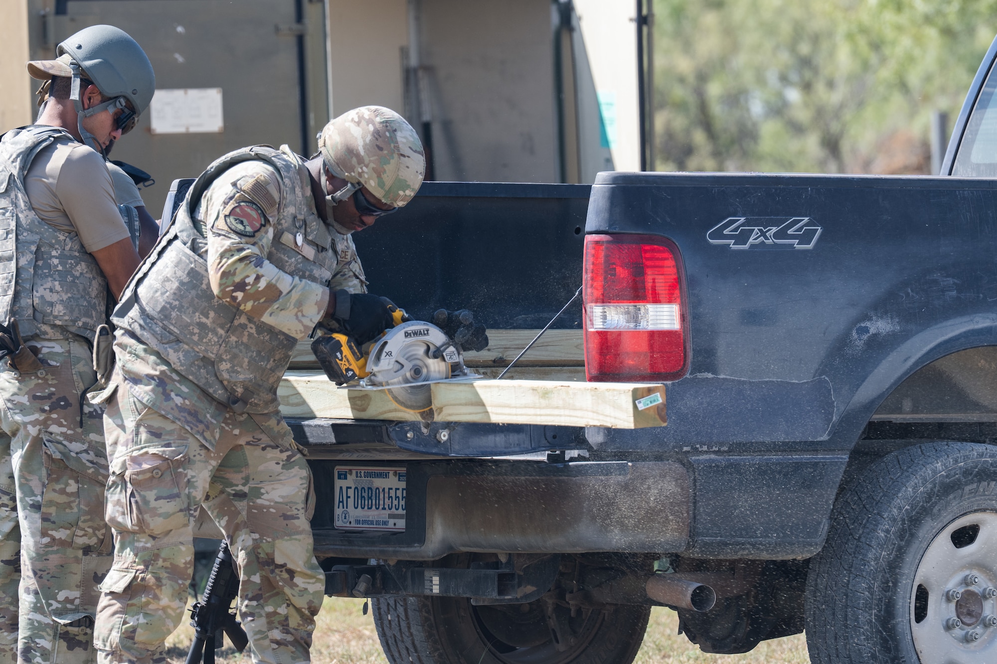 U.S. Air Force Airman 1st Class Christopher Sill, 7th Civil Engineer Squadron structural apprentice, cuts a wood beam during exercise Coyote Shield at Dyess Air Force Base, Texas, Oct. 16, 2025. Airmen from the 7th CES and 7th Security Forces Squadron gained experience in recovering base operations, receiving support forces, and re-establishing command and control, increasing the 7th Bomb Wing's readiness to respond in degraded conditions. (U.S. Air Force photo by Airman 1st Class Caleb Schellenberg)