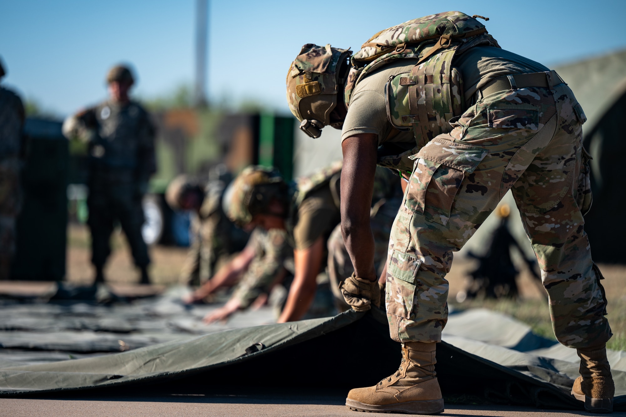 U.S. Airmen assigned to the 7th Security Forces Squadron and 7th Civil Engineer Squadron disassemble a tent during exercise Coyote Shield at Dyess Air Force Base, Texas, Oct. 17, 2025. Coyote Shield provided Airmen from the 7th CES and 7th Security Forces Squadron valuable dual training opportunities, ensuring 7th Bomb Wing Airmen remain ready for any mission. (U.S. Air Force photo by Senior Airman Jade M. Caldwell)