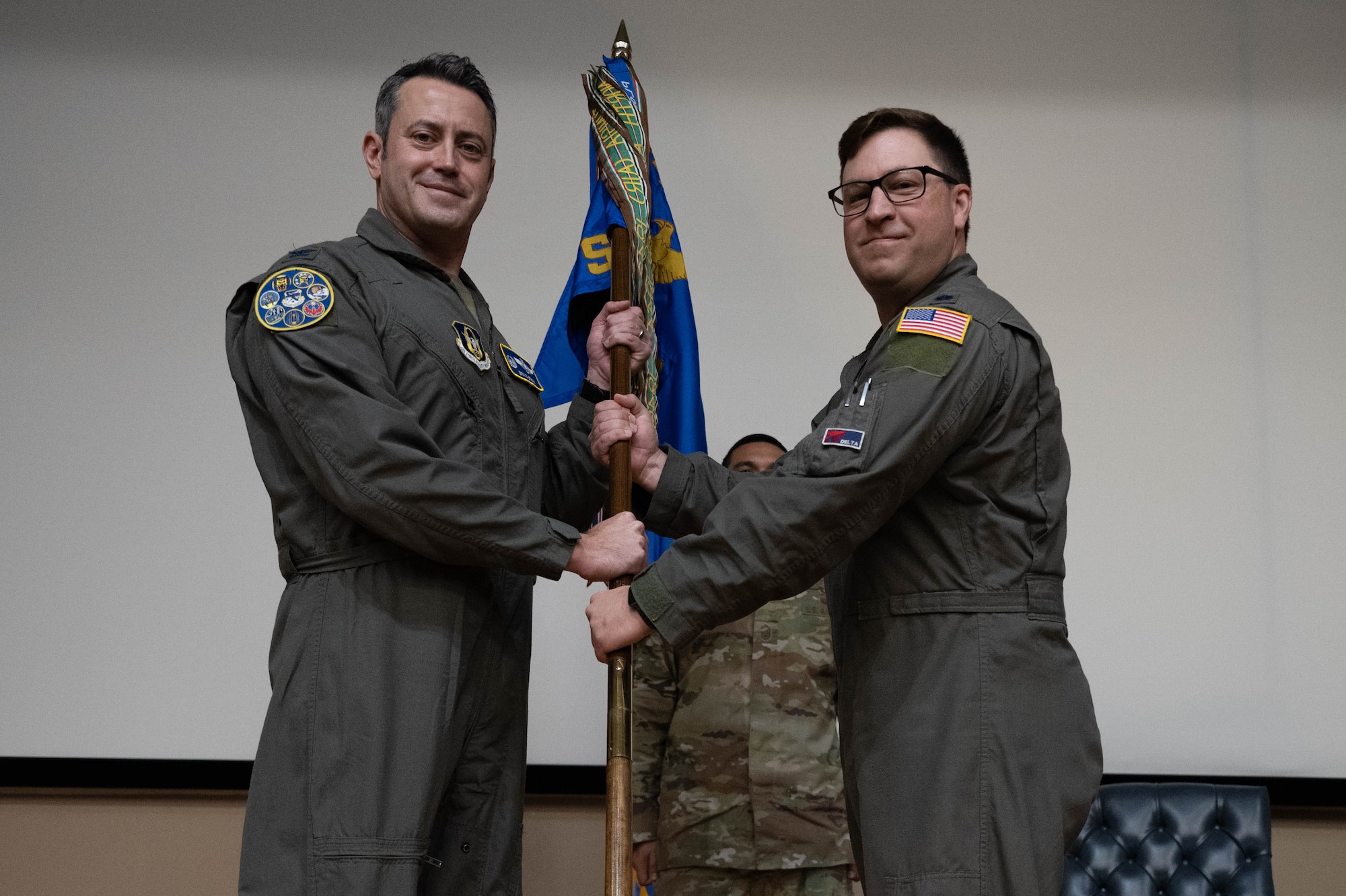 U.S. Air Force Lt. Col. Andrew Calhoun, outgoing commander of the 96th Flying Training Squadron, relinquishes the guidon of the 96th FTS to Col. Anthony Straw, 340th Flying Training Group commander, during the 96th FTS change of command ceremony at Laughlin Air Force Base, Texas, Nov. 7, 2025.  The ceremony served as the official transition of command authority within the squadron. (U.S. Air Force photo by Airman 1st Class Darryl Keith.)