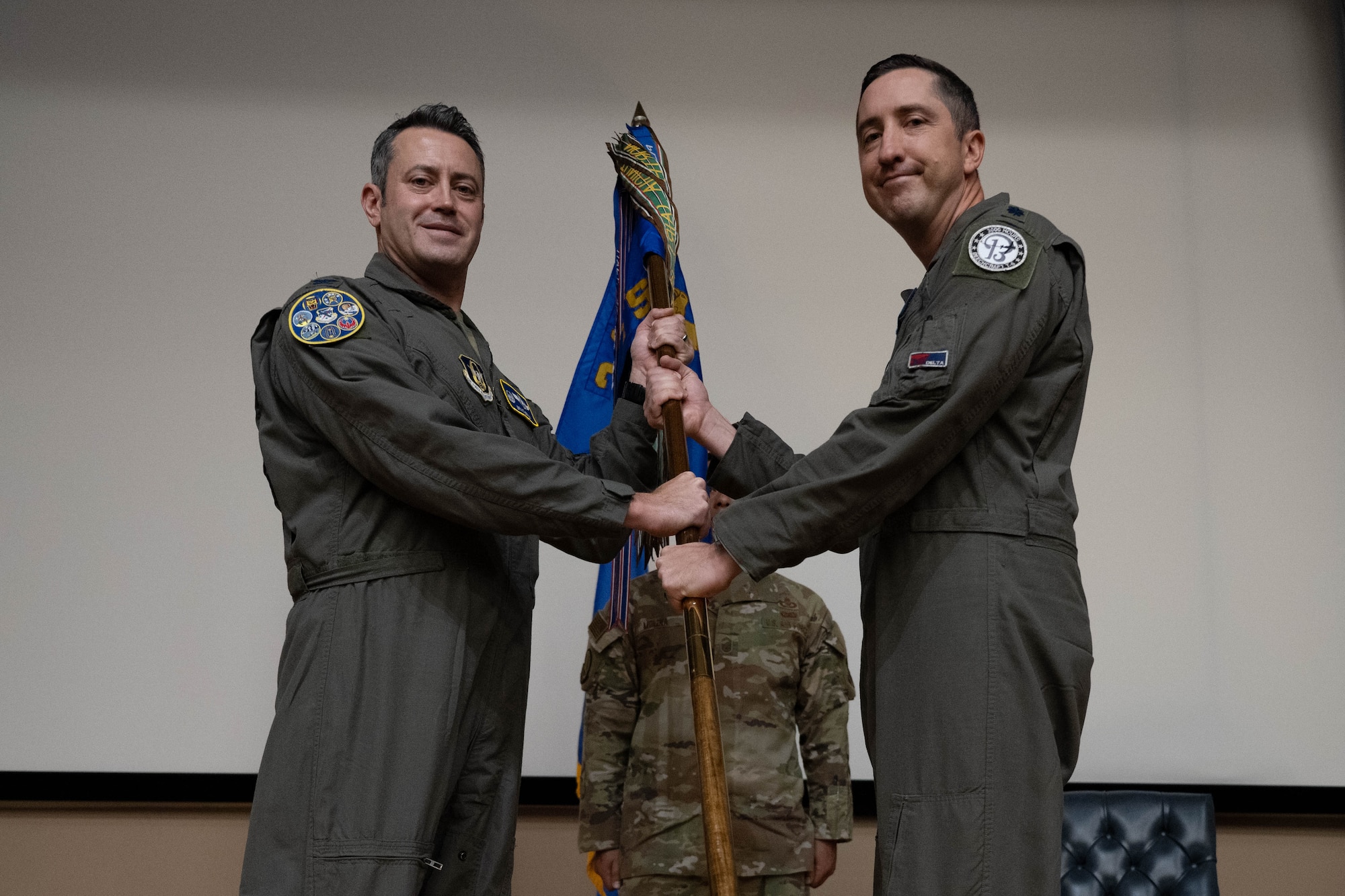U.S. Air Force Col. Anthony Straw, 340th Flying Training Group commander, passes the guidon of the 96th Flying Training Squadron to Lt. Col. Daniel Yawn, incoming 96th FTS commander, at a change of command ceremony at Laughlin Air Force Base, Texas, Nov. 7, 2025.  The ceremony served as the official transition of command authority within the squadron. (U.S. Air Force photo by Airman 1st Class Darryl Keith.)