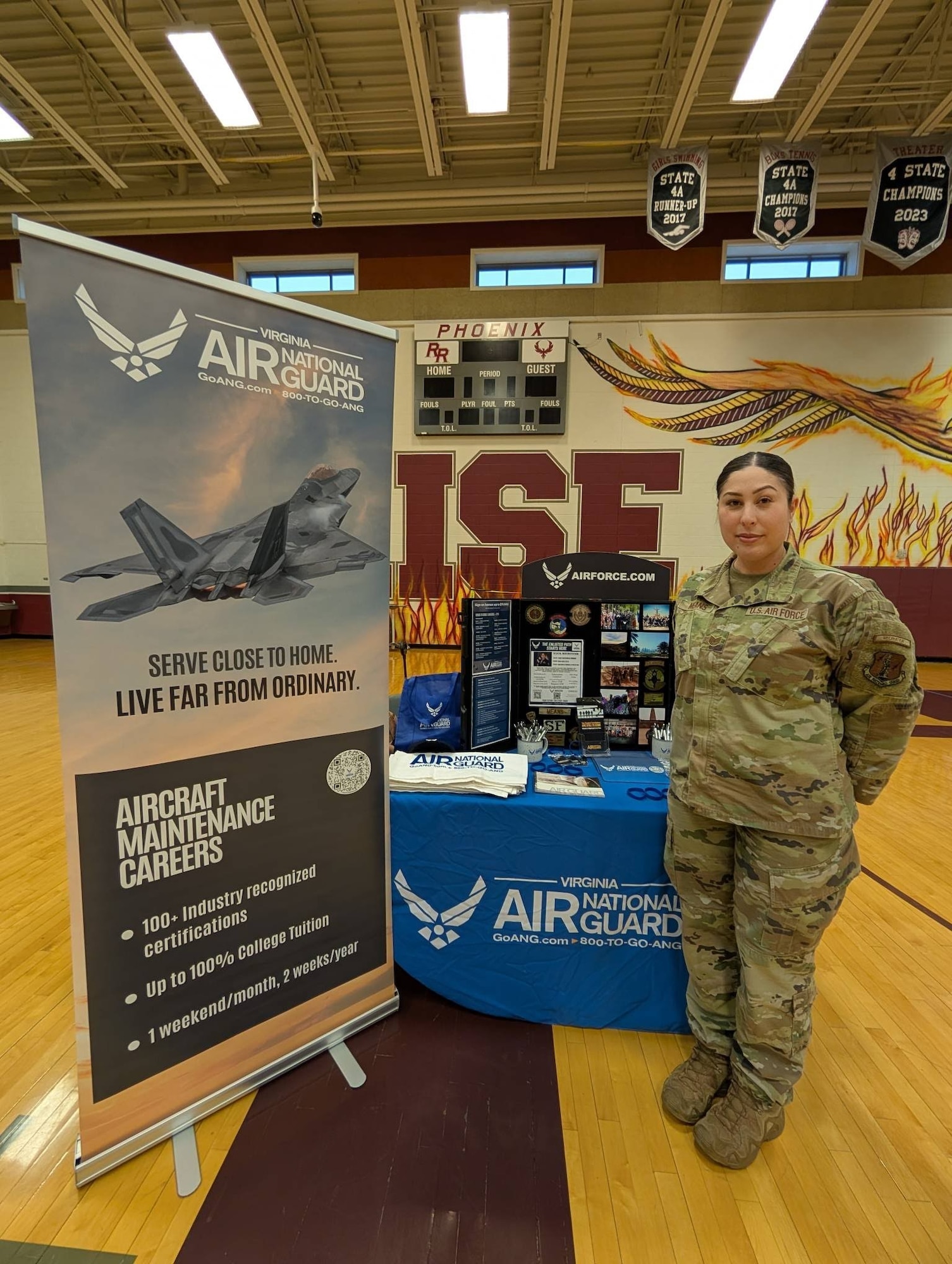 Tech. Sgt. Raychelle Means poses for a photo in front of the Virginia Air National Guard recruiting booth at Rock Ridge High School in Ashburn, Virginia.