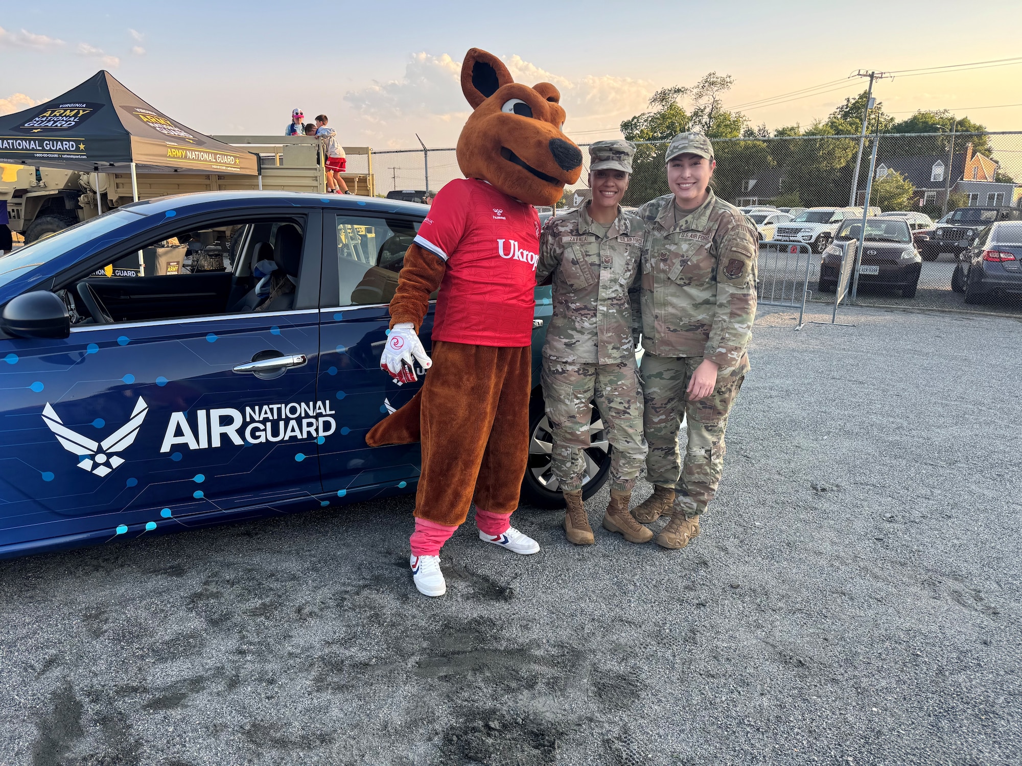 Tech. Sgt. Alexandria Zavala, center, and Tech. Sgt. Raychelle Means pose for a photo with the Ukrops mascot during a recruiting event.