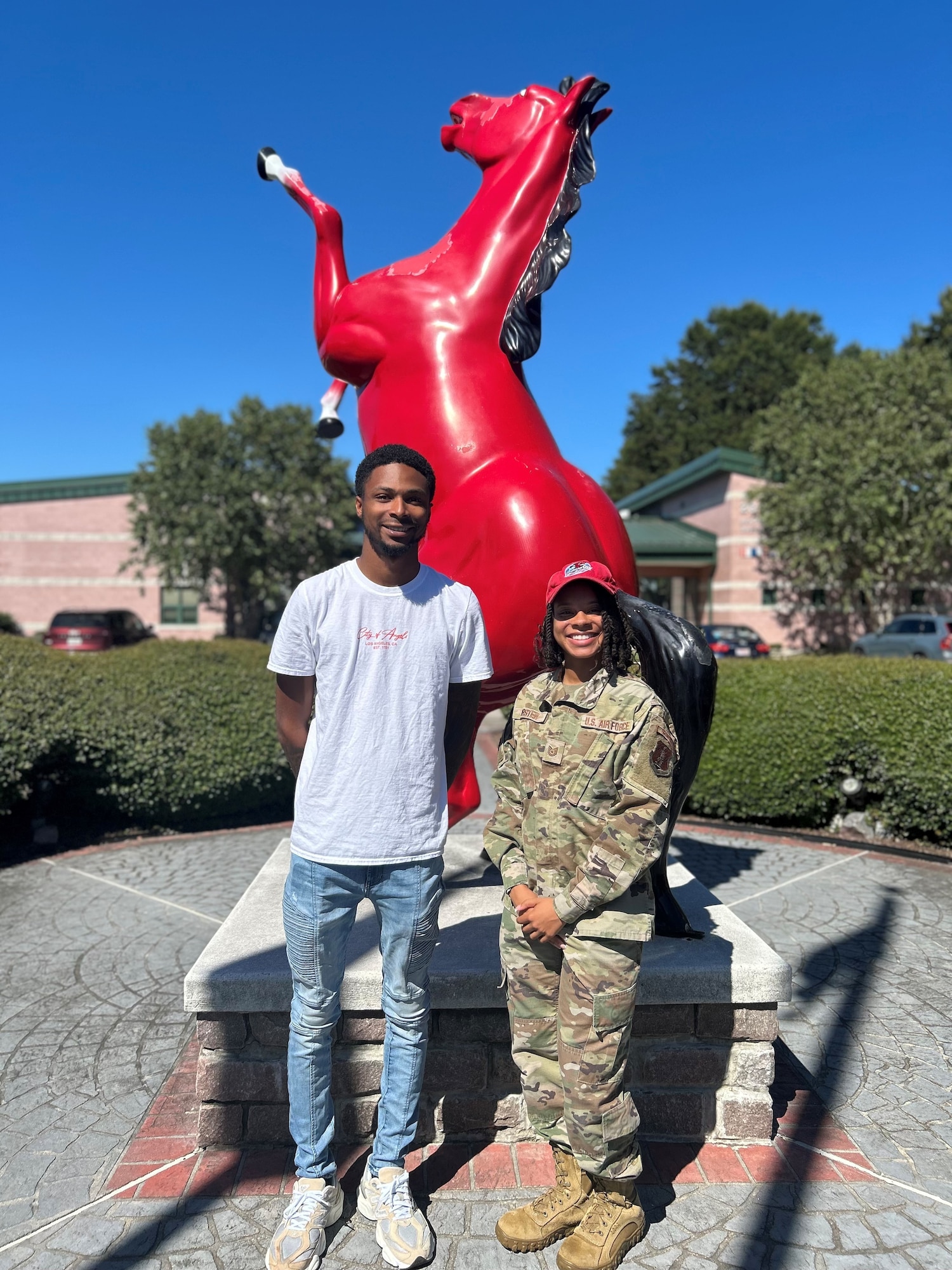 Tech. Sgt. Tatiana Forster, right, poses for a photo with a new Virginia Air National Guard recruit in front of the 203rd RED HORSE statue.