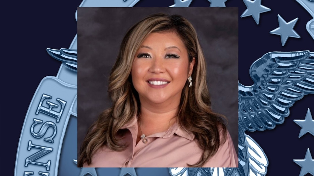 headshot of woman long, wavy brown hair and a rose-colored shirt