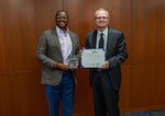 NSWCPD Technical Director Nigel C. Thijs, SES, presents Thomas M. Miller with the Department of the Navy Civilian Service Achievement Medal in recognition of his exceptional professional achievement as the Machinery Silencing RDT&E Lead for the Columbia Class Submarine Program. Throughout his 40-year career, Miller’s visionary leadership and technical expertise were instrumental in advancing submarine stealth through innovative quieting technologies and methodologies—critical to maintaining the U.S. Navy’s strategic advantage in undersea warfare. (U.S. Navy photo by Jay Butterbaugh, CTR)