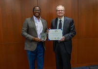 NSWCPD Technical Director Nigel C. Thijs, SES, presents Thomas M. Miller with the Department of the Navy Civilian Service Achievement Medal in recognition of his exceptional professional achievement as the Machinery Silencing RDT&E Lead for the Columbia Class Submarine Program. Throughout his 40-year career, Miller’s visionary leadership and technical expertise were instrumental in advancing submarine stealth through innovative quieting technologies and methodologies—critical to maintaining the U.S. Navy’s strategic advantage in undersea warfare. (U.S. Navy photo by Jay Butterbaugh, CTR)