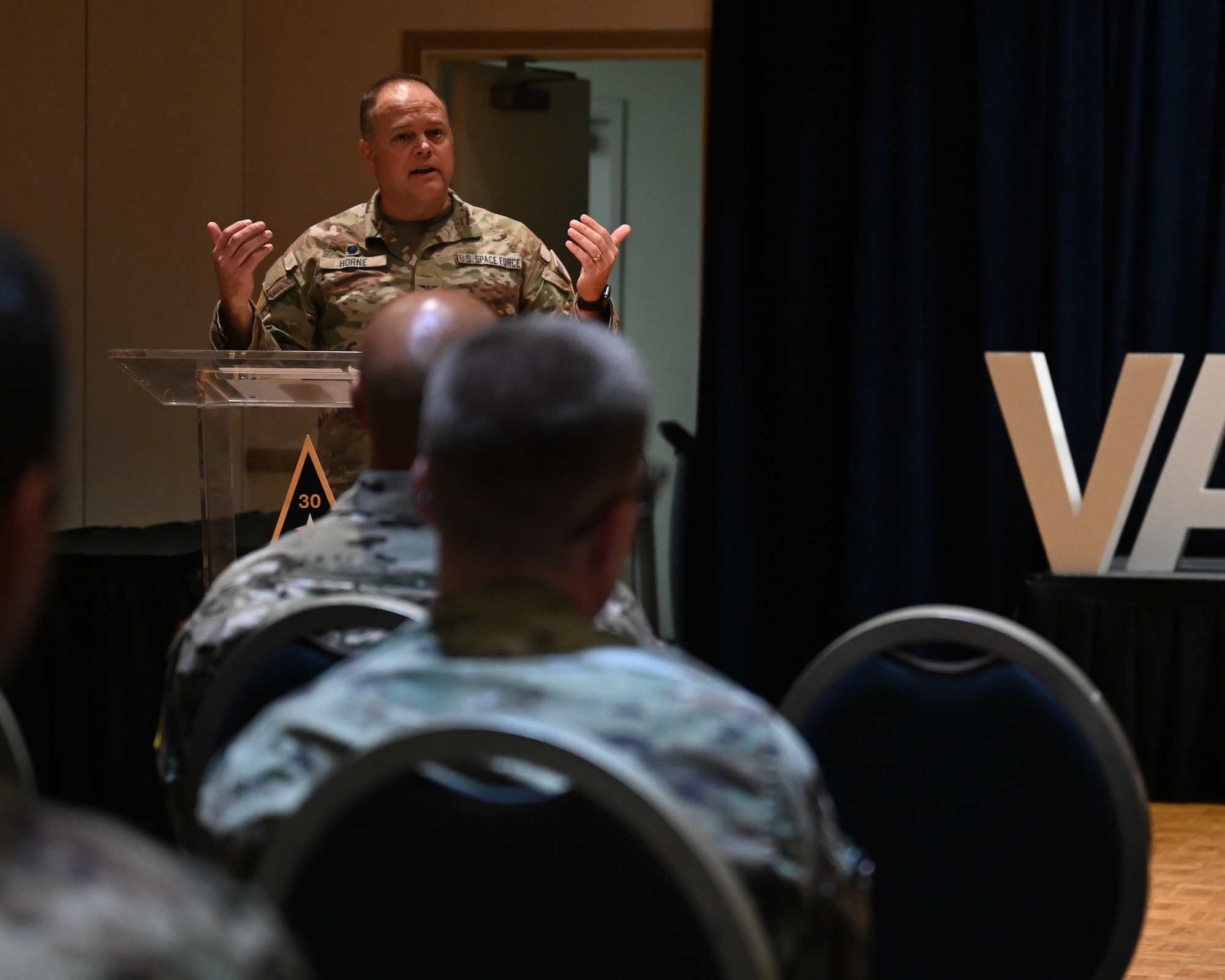 U.S. Space Force Colonel James Horne, Space Launch Delta 30 commander motions with his hands to a crowd of people during a Vandenberg First Sergeant Symposium.