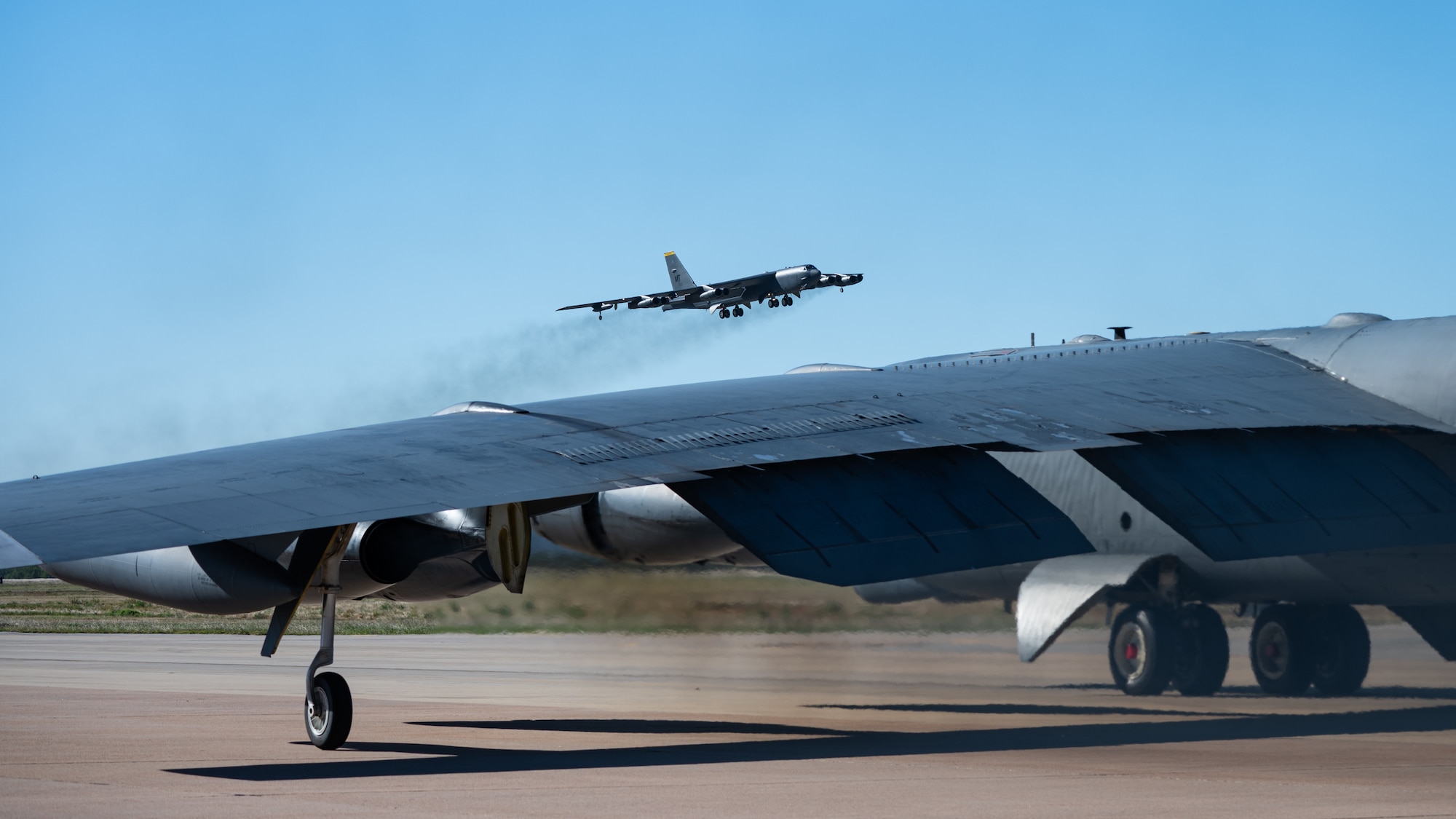 A U.S. Air Force B-52 Stratofortress, stationed at Minot Air Force Base, North Dakota, departs the airfield while a B-52, stationed at Barksdale AFB, Louisiana, taxis prior to departure as part of Exercise Global Thunder 26 at Dyess AFB, Texas, Oct. 29, 2025. Global Thunder is an annual command and control exercise designed to train U.S. Strategic Command Forces and assess joint operational readiness. (U.S. Air Force photo by Senior Airman Jade M. Caldwell)