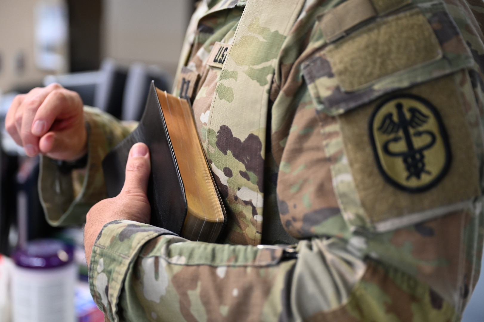 Chaplain (Capt.) Steven Troupe holds a Bible to his chest before offering a Blessing of the Hands at Carl R. Darnall Army Medical Center on Fort Hood, Texas. Troupe personally performed the Blessing of the Hands for over 50 individuals during Pastoral Care Week.