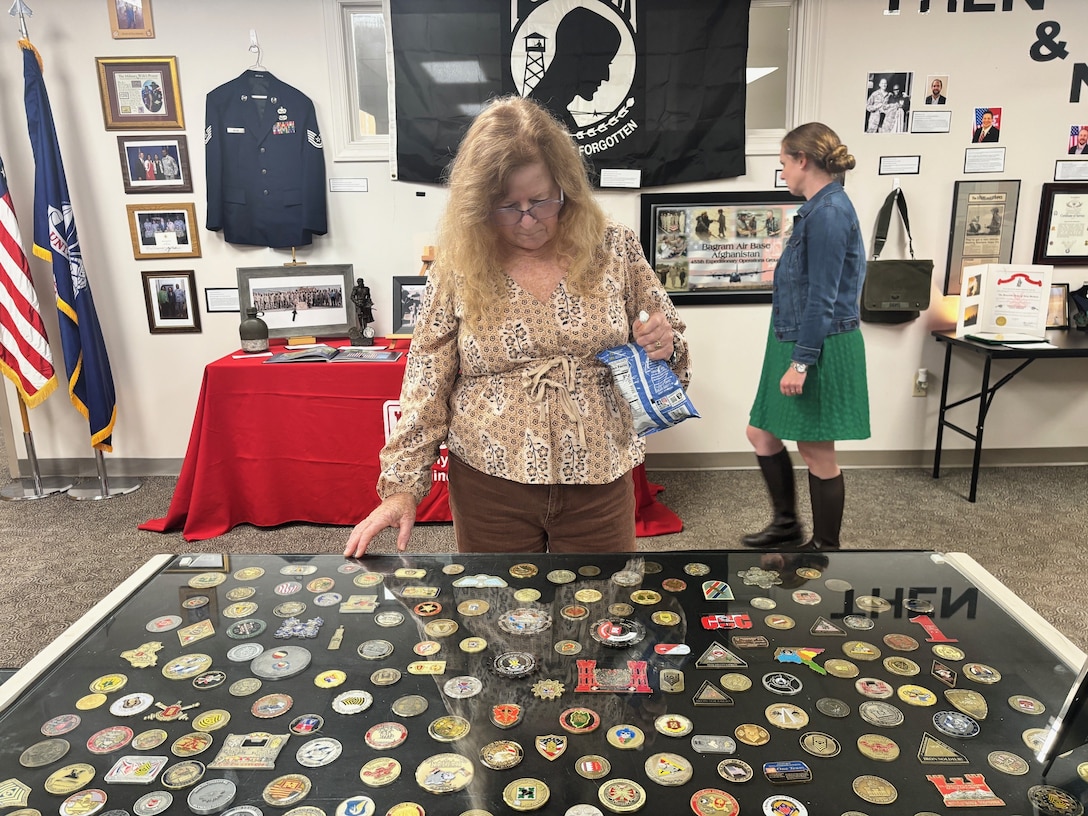 Lynne Schweitzer, U.S. Army Corps of Engineers, Savannah District, Construction Division, views a large challenge coin collection during her visit to the District’s “Veterans Legacy Exhibition.”  Hosted by the Employee Recreation Association, the exhibit runs November 3-21, 2025.