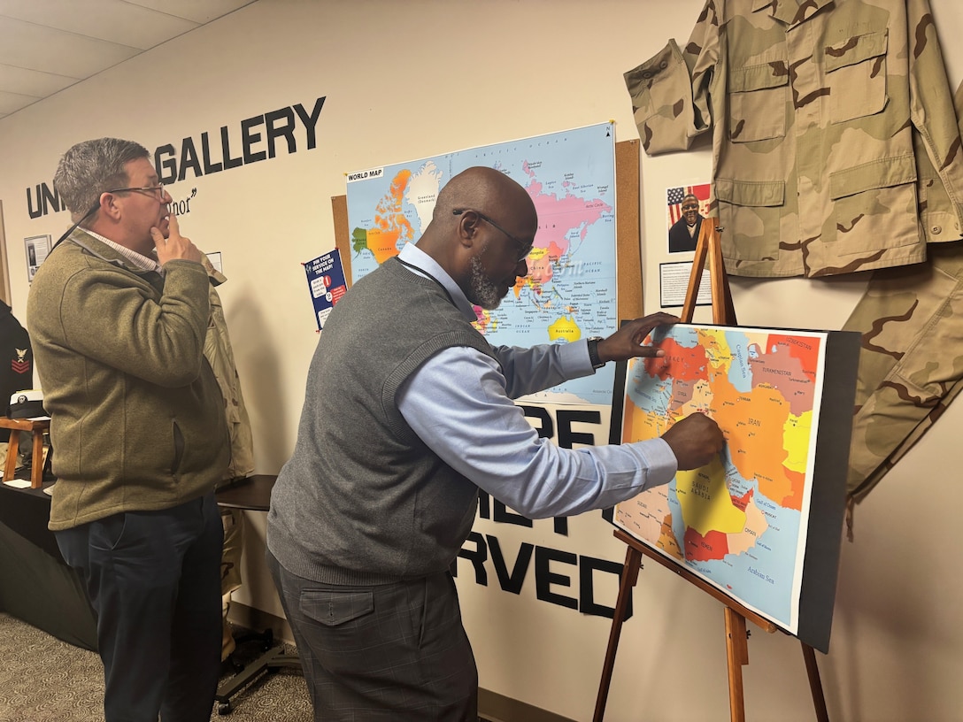 U.S Army Corps of Engineers, Savannah District Equal Employment Specialist Samuel Robinson, uses push pins to identify the places that he’s served while in the military as Ben Garrett, chief of Corporate Communications for the District looks on. The display is part of a ‘Veteran’s Legacy Exhibition” hosted by the Savannah District’s Employee Recreation Association to honor Veterans.