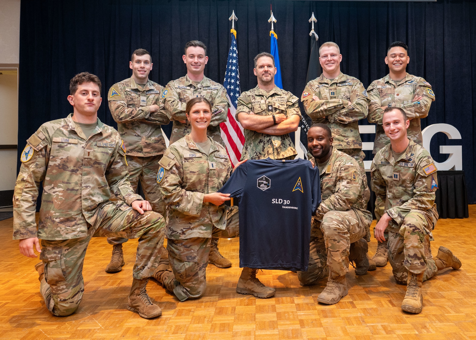 Team Vandenberg competitors from Space Launch Delta 30 team 1, team 2, U.S. Space Forces - Space, and Delta 5 kneel in the front and stand in the back for a photo.