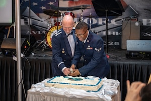 U.S. Air Force Col. Matthew Gaetke, left, U.S. Forces Korea J3 Director of Staff, and Airman 1st Class Ryan Woods, 51st Communications Squadron command support staff, cut the first slice of cake for the ceremonial cake-cutting during the 2025 Air Force Ball in Seoul, Republic of Korea, Oct. 10, 2025.