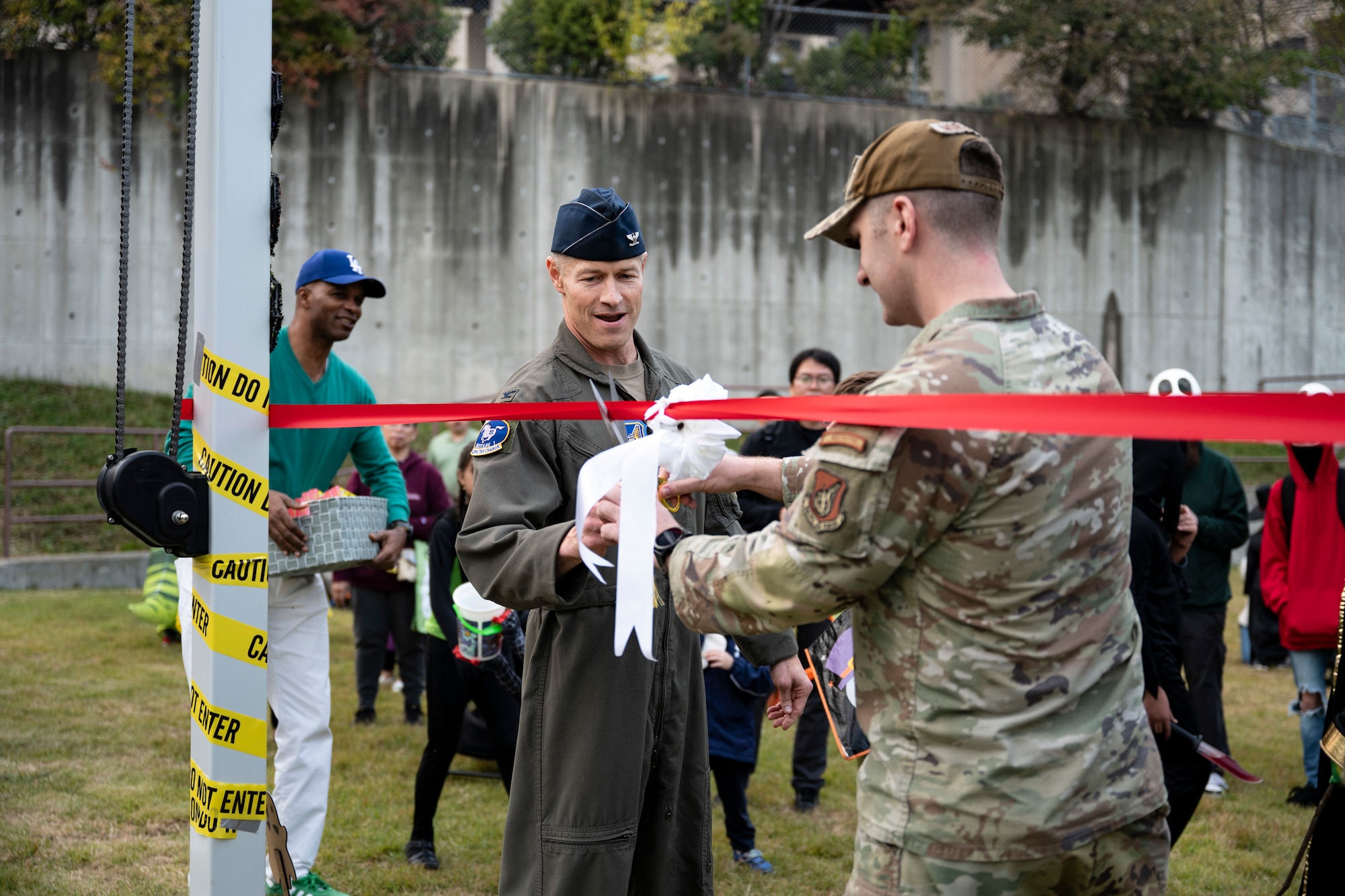 U.S. Air Force Col. Ryan Ley, 51st Fighter Wing commander, cuts a ribbon to officially open Dinosaur Park at Osan Air Base, Republic of Korea, Oct. 31, 2025.