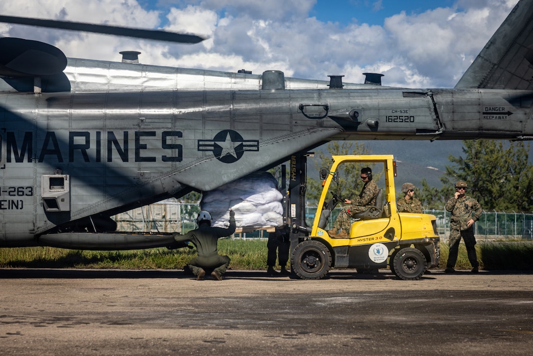 A forklift loading a helicopter with supplies