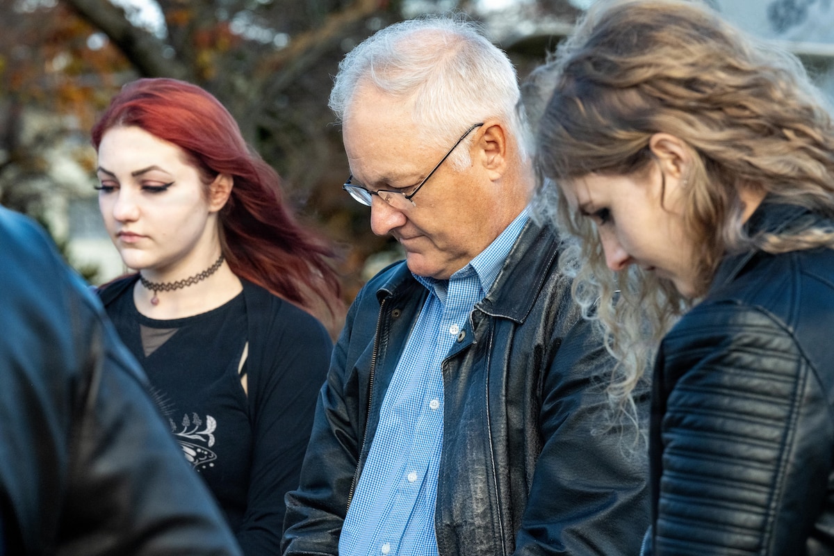 Retired U.S. Air Force Lt. Col. William “Mother” Forkner, Air Education and Training Command chief of combat air forces training branch, bows his head alongside his two daughters for a moment of prayer during a Veterans Day remembrance ceremony.