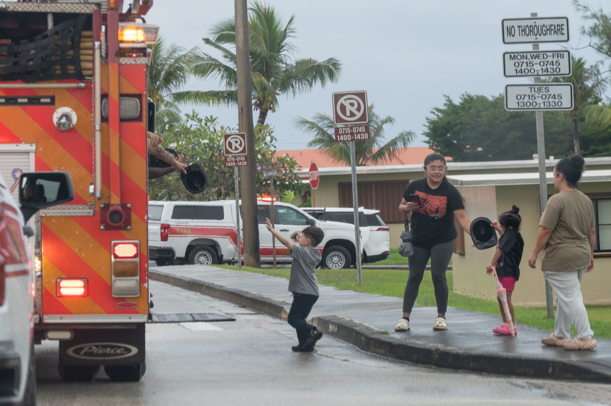 Fire fighters from the 36th Civil Engineer Squadron Fire Department pass out helmets to parade-goers during the 2025 Fire Prevention Week Housing Parade at Andersen Air Force Base, Guam, Oct. 7, 2025.