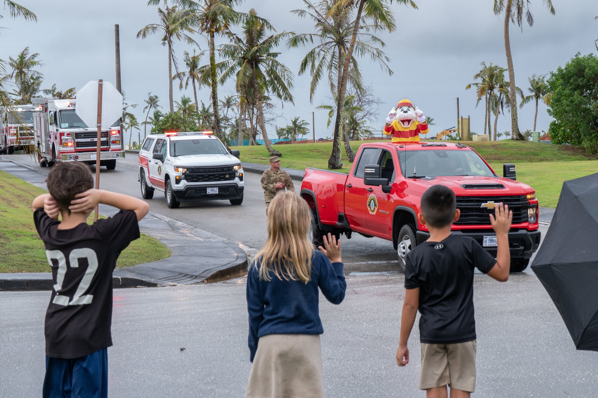 Children watch as Sparky, the 36th Civil Engineer Squadron Fire Department mascot, passes by during the 2025 Fire Prevention Week Housing Parade at Andersen Air Force Base, Guam, Oct. 7, 2025.