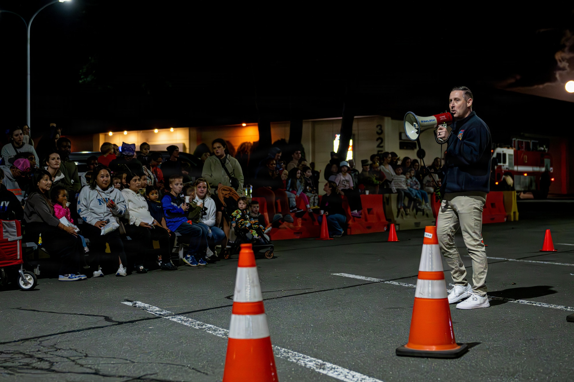 U.S. Air Force Master Sgt. Christopher Edington, right, 35th Civil Engineer Squadron assistant chief for prevention, announces the events of a simulated burning aircraft training during Fire Prevention Week 2025.