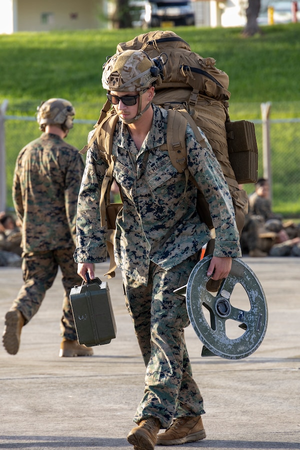 U.S. Marine Corps Lance Cpl. Nathan Pigeon, a mortarman with Weapons Company, Battalion Landing Team 1st Battalion, 7th Marine Regiment, 31st Marine Expeditionary Unit, transports gear during flight operations at Marine Corps Air Station Futenma, Okinawa, Japan, Sept. 26, 2025. The Marines conducted flight operations demonstrating multi-domain transport capabilities of the 31st MEU. The 31st MEU, the Marine Corps’ only continuously forward-deployed MEU, provides a flexible and lethal force, ready to perform a wide range of military operations as the premiere crisis response force in the Indo-Pacific region. Pigeon is a Native of California. (U.S. Marine Corps photo by Lance Cpl. Skilah Sanchez)