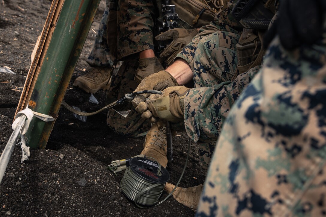 U.S. Marines with Battalion Landing Team 1st Battalion, 7th Marine Regiment, 31st Marine Expeditionary Unit, crimp a detonating cord charge to the fuse during live-fire training at Combined Arms Training Center, Camp Fuji, Japan, Sept. 29, 2025. Marines conducted combined arms live-fire training to maintain operational readiness, tactical proficiency, and enhance lethality while operating within the first island chain. The 31st MEU, the Marine Corps’ only continuously forward-deployed MEU, provides a flexible and lethal force ready to perform a wide range of military operations as the premiere crisis response force in the Indo-Pacific region. (U.S. Marine Corps photo by Lance Cpl. Victor Gurrola)
