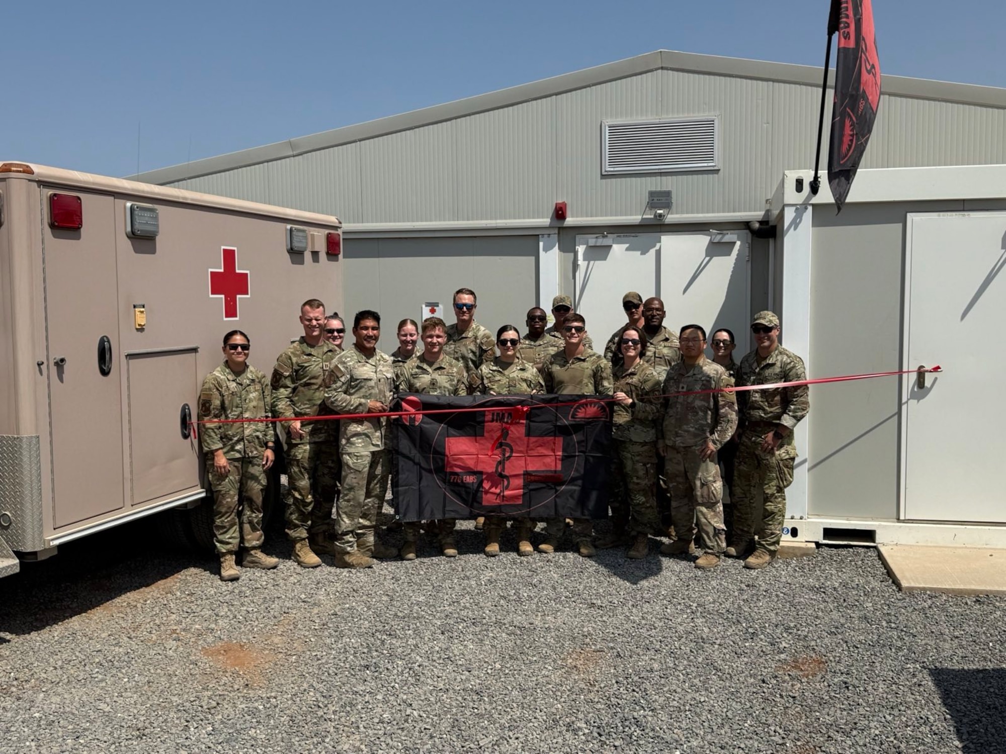 U.S. Air Force Airmen assigned to the 776th Expeditionary Air Base Squadron pose for a photo in front of a new Joint Medical Aid Station building at Chabelley Airfield, Djibouti.