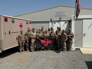 U.S. Air Force Airmen assigned to the 776th Expeditionary Air Base Squadron pose for a photo in front of a new Joint Medical Aid Station building at Chabelley Airfield, Djibouti.