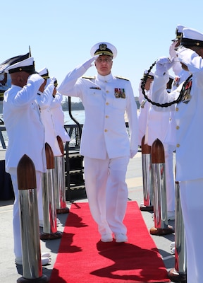 Rear Adm. Frank Brajevic, Reserve deputy director of Medical Forces Pacific, salutes while being piped ashore at the conclusion of his promotion ceremony aboard the USS Midway on Oct. 4, 2025, a tradition that honors naval heritage and reflects the significance of his new role as Reserve deputy director of Medical Forces Pacific. (U.S. Navy Photo by Petty Officer 1st Class Nikki Smith)