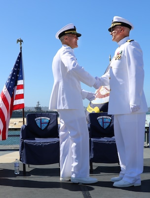 Rear Adm. Kevin Brown, commander of Naval Medical Forces Pacific, and Rear Adm. Frank Brajevic, Reserve deputy director of Medical Forces Pacific, shake hands following Brajevic’s promotion ceremony on Oct. 4, 2025 aboard the USS Midway, a historic aircraft carrier that served in pivotal conflicts from World War II to the Vietnam War. (U.S. Navy Photo by Petty Officer 1st Class Nikki Smith)