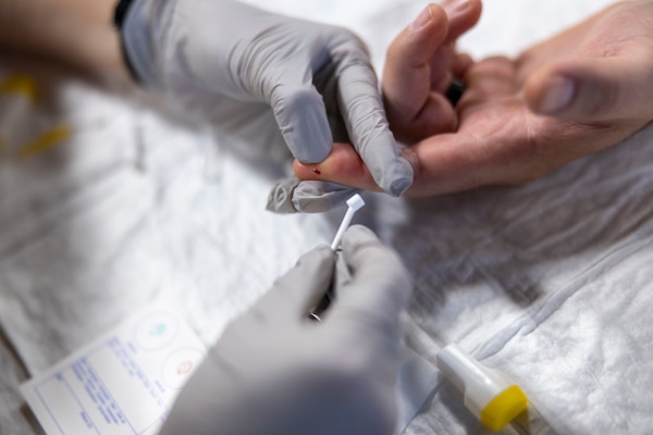 U.S. Navy LT. Cmdr. Alexandria Johnston, a medical officer assigned to the Harpers Ferry-Class Dock Landing Ship USS Carter Hall (LSD 50), takes a blood sample from a fellow classmate during a Tier IV Tactical Casualty Combat Care course hosted by 2nd Marine Logistics Group at Marine Corps Base Camp Lejeune, North Carolina, Sept. 29, 2025. 2nd MLG became the first-ever Marine Corps command to host a Tier IV TCCC course and is now hosting its second iteration. The course trains select military service members to become proficient combat paramedics capable of providing advanced casualty care at the point of injury on the battlefield and in austere environments. (U.S. Marine Corps photo by Lance Cpl. Isabella Ramos)