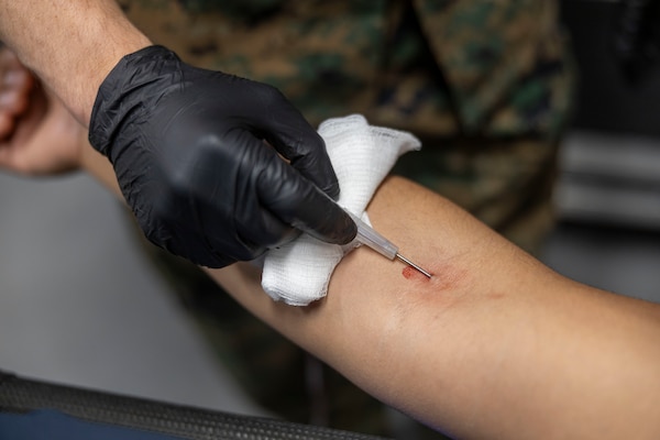 U.S. Navy LT. Soterios Stroud, an emergency medicine specialist, with 2nd Medical Battalion, 2nd Marine Logistics Group, practices drawing blood during a Tier IV Tactical Casualty Combat Care course at Marine Corps Base Camp Lejeune, North Carolina, Sept. 29, 2025. 2nd MLG became the first-ever Marine Corps command to host a Tier IV TCCC course and is now hosting its second iteration. The course trains select military service members to become proficient combat paramedics capable of providing advanced casualty care at the point of injury on the battlefield and in austere environments. (U.S. Marine Corps photo by Lance Cpl. Isabella Ramos)