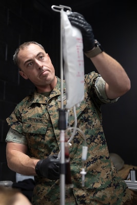 U.S. Navy Lt. j.g. Derrick Reddick, a field medical technician with 2nd Medical Battalion, 2nd Marine Logistics Group, practices blood transfusions during a Tier IV Tactical Casualty Combat Care course at Marine Corps Base Camp Lejeune, North Carolina, Sept. 29, 2025. 2nd MLG became the first-ever Marine Corps command to host a Tier IV TCCC course and is now hosting its second iteration. The course trains select military service members to become proficient combat paramedics capable of providing advanced casualty care at the point of injury on the battlefield and in austere environments. (U.S. Marine Corps photo by Lance Cpl. Isabella Ramos)