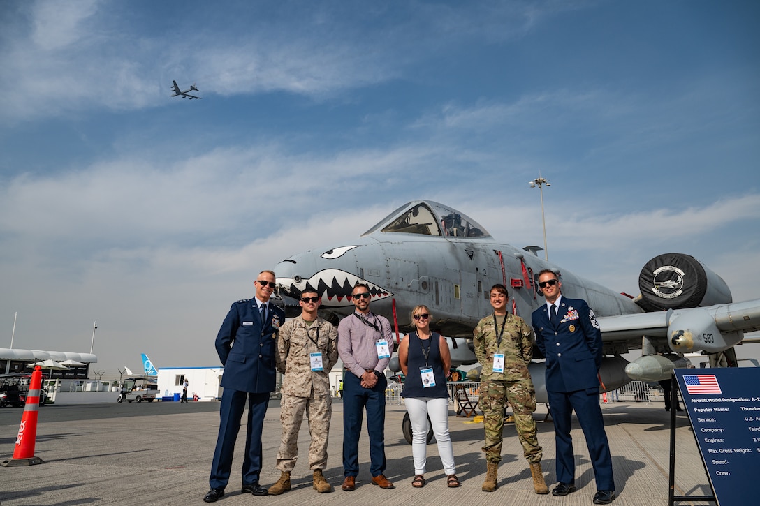 U.S. Air Force Lt. Gen. Derek France, Air Forces Central commander, stands with service members and Department of War civilians in front of an A-10 Thunderbolt aircraft while a B-52 Stratofortress aircraft flies in the background at the Al Maktoum International Airport, Dubai, Nov. 17, 2025. They attended the Dubai International Airshow, an event that strengthens ties between U.S. forces and international partners in aviation and national defense. (U.S. Air Force photo by Tech. Sgt. Justin Norton)