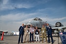 U.S. Air Force Lt. Gen. Derek France, Air Forces Central commander, stands with service members and Department of War civilians in front of an A-10 Thunderbolt aircraft while a B-52 Stratofortress aircraft flies in the background at the Al Maktoum International Airport, Dubai, Nov. 17, 2025. They attended the Dubai International Airshow, an event that strengthens ties between U.S. forces and international partners in aviation and national defense. (U.S. Air Force photo by Tech. Sgt. Justin Norton)
