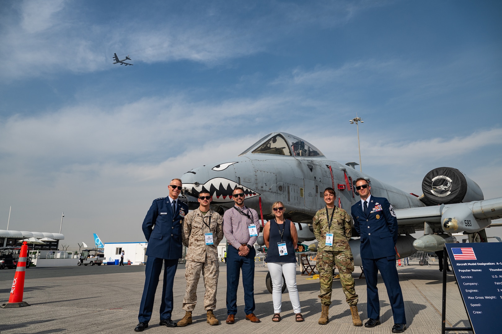 U.S. Air Force Lt. Gen. Derek France, Air Forces Central commander, stands with service members and Department of War civilians in front of an A-10 Thunderbolt aircraft while a B-52 Stratofortress aircraft flies in the background at the Al Maktoum International Airport, Dubai, Nov. 17, 2025. They attended the Dubai International Airshow, an event that strengthens ties between U.S. forces and international partners in aviation and national defense. (U.S. Air Force photo by Tech. Sgt. Justin Norton)