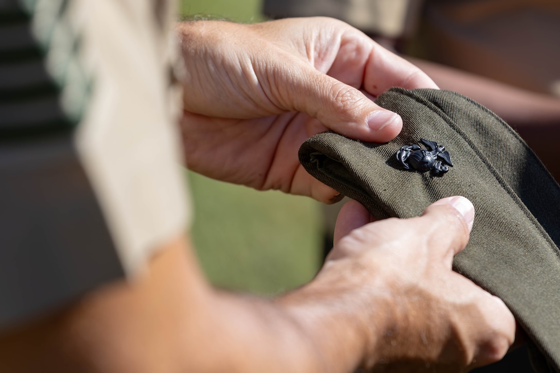 An Eagle, Globe, and Anchor on a U.S. Marine Corps garrison cover is inspected during a uniform inspection at Marine Corps Support Facility New Orleans, Oct. 24, 2025. The inspection was conducted to evaluate the Marines’ appearance and adherence to standards while promoting discipline and attention to detail. (U.S. Marine Corps photo by Lance Cpl. Van Hoang)