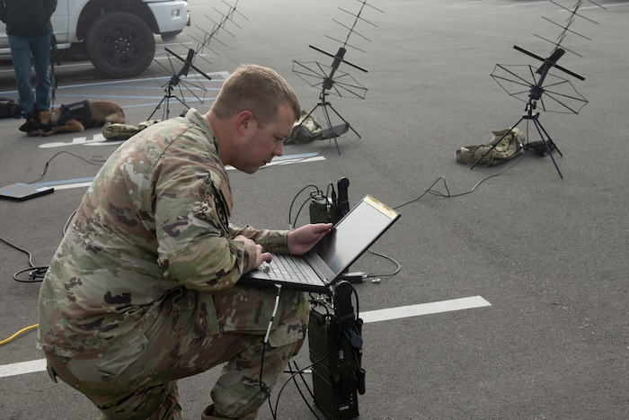 Airman using computer and radio for communication